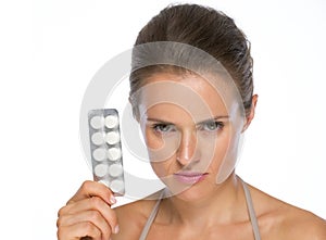 Serious woman showing blistering package of pills