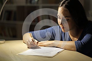 Woman signs contract at night at home