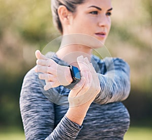 Serious, woman and stretching arms for exercise, training and sports in park. Focused female athlete warm up in workout