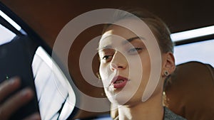 Serious woman talking mobile phone at car. Business woman making video call.