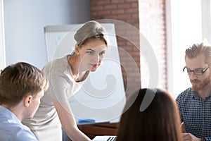 Serious woman team leader listening to ideas at group brainstorm