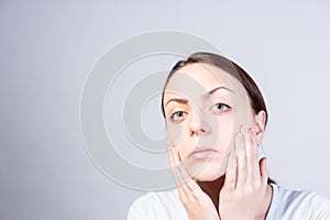 Serious Woman Touching her Face with Two Hands