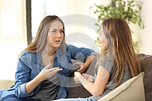 Serious women talking on a couch at home