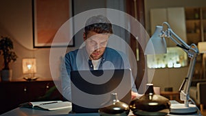 Serious worker checking phone sms in late interior closeup. Man typing laptop