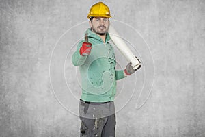 A serious worker with construction plans in his hand, thumb up