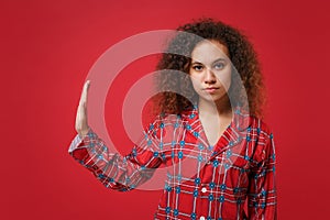 Serious young african american girl in pajamas homewear posing resting at home isolated on red background. Relax good