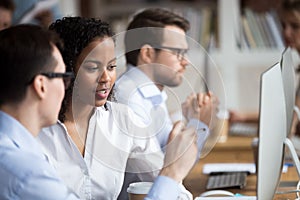 Serious young African American woman talking with colleague