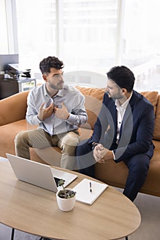 Serious young Arab employee man talking to Indian colleague photo