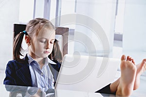 Serious young beautiful  business girl working in office with bare feet up. Selective focus on eyes