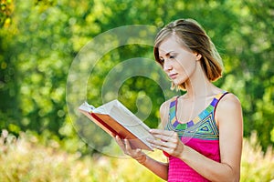 Serious young beautiful woman holding red book