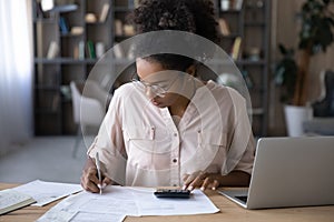 African American woman manage budget paying bills online photo