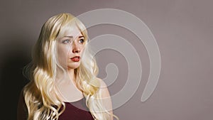 Serious young blonde woman looking to side thinking