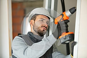 serious young builder using cordless drill