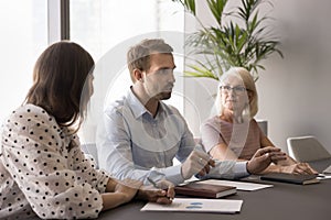 Serious young business professional man talking to colleagues