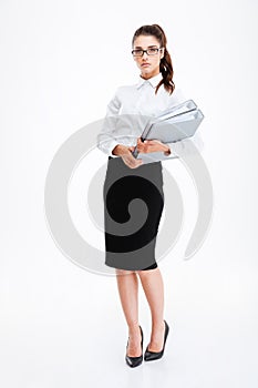 Serious young business woman standing and holding folders