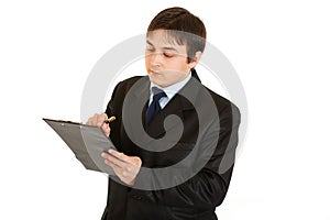 Serious young businessman making notes in document