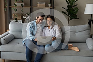 Serious young couple holding laptop consider on wedding planning