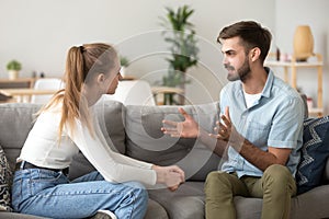 Serious young couple sitting together, talking about relationships photo