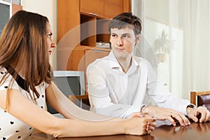 Serious young couple talking in home