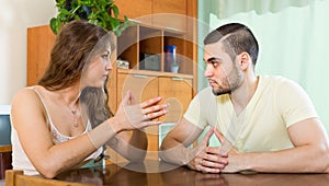 Serious young couple talking at home