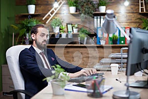 Serious young entrepreneur working on computer in his office