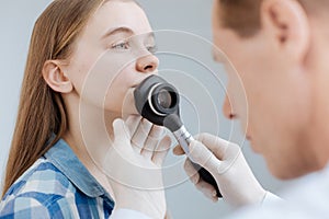 Serious young girl having appointment with dermatologist in the clinic