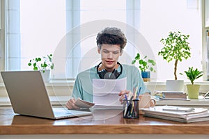 Serious young guy reading letter, paper document