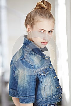 Serious young lady in jeans jacket.
