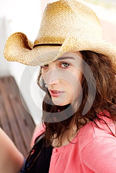 Serious young lady sitting outside wearing hat