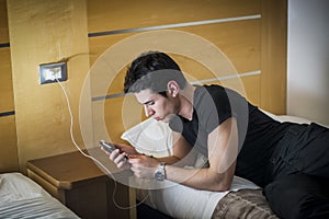 Serious Young Man Connecting a Phone to a Charger