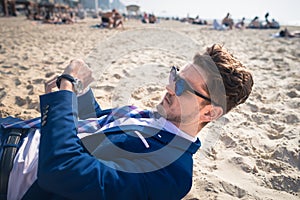 Serious young man in elegant suit is late on the work. Stylish guy