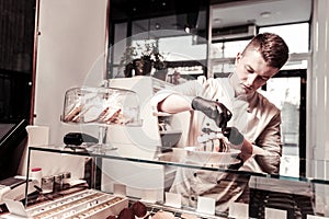 Serious young man focusing on pastry decoration