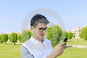 Serious young man outdoor with mobile phone.