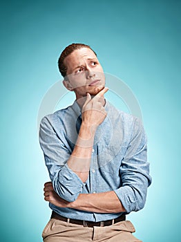 The serious young man over blue background