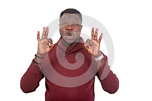 Serious young man showing okay sign with his fingers