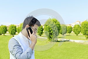 Serious young man talking on mobile phone.