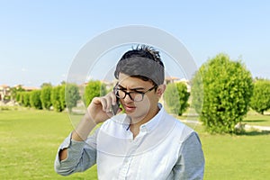 Serious young man talking on phone.