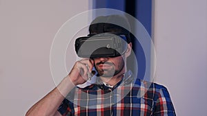 Serious young man in virtual reality glasses talking on the phone