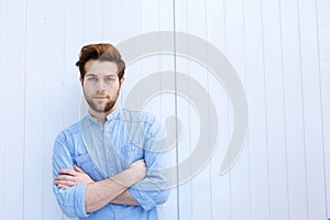 Serious young modern man standing with arms crossed