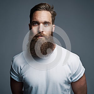 Serious young muscular man with large fuzzy beard