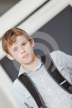 Serious young school boy in a tilted angle view