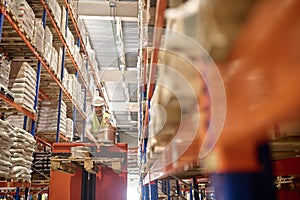 Serious young warehouse loader dealing with good