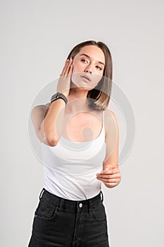 Serious young woman applying face cream