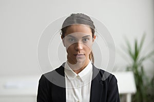 Serious young woman business leader looking at camera, headshot