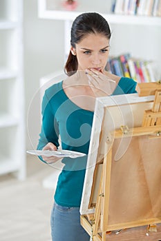 serious young woman painting at art studio