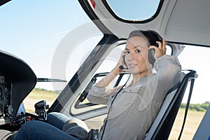 Serious young woman pilot in headset sitting in plane
