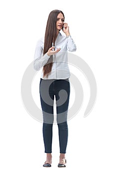 Serious young woman talking on her smartphone. isolated on white