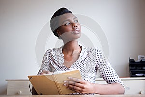 Serious young woman thinking and writing in journal