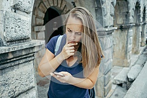 Serious Young woman traveler in a blue T-shirt with backpack loo