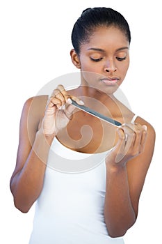 Serious young woman using nail file photo